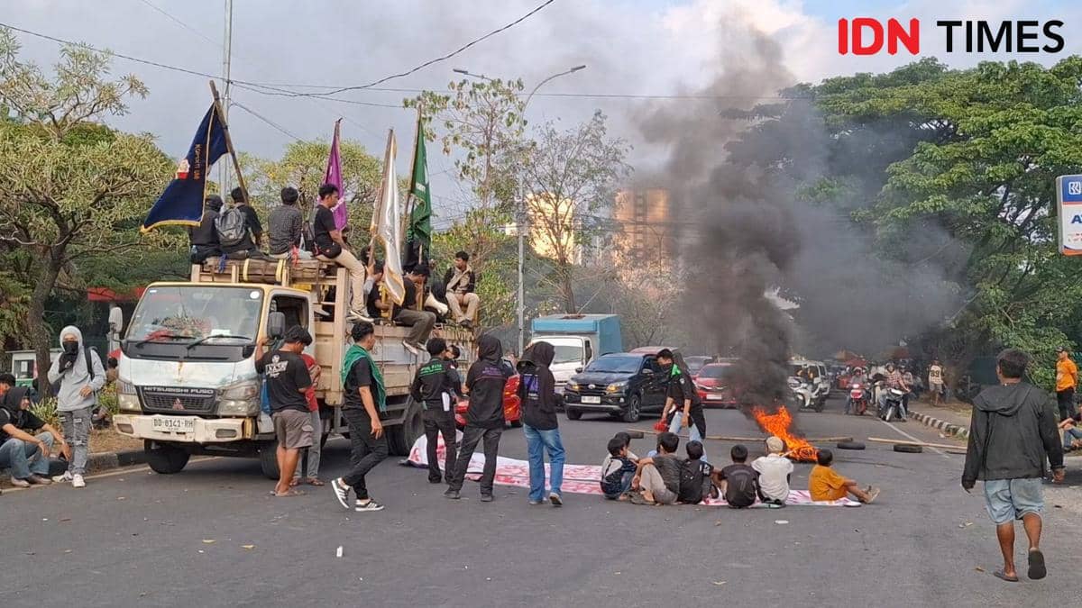 Sejumlah mahasiswa UMI memblokade Jalan Urip Sumoharjo Makassar dengan membakar ban dan membawa bendera saat aksi peringatan Amarah 2026.