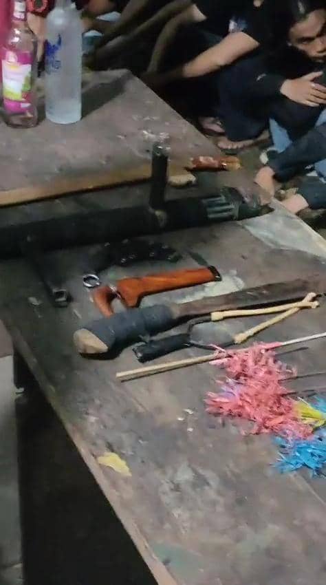 Barang bukti berupa busur, badik, parang, dan pappori diletakkan di atas meja kayu setelah disita oleh pihak kepolisian.