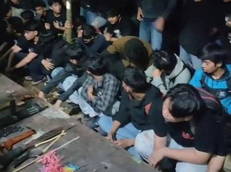 Sekelompok mahasiswa duduk berdesakan di lantai setelah diamankan usai bentrok dengan pengemudi ojek online di Makassar.