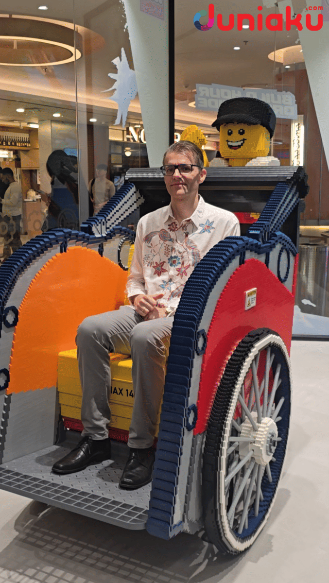 Per Brixen di becak yang terbuat dari balok LEGO di dalam toko LEGO Certified Store Grand Indonesia dengan latar interior mal modern.