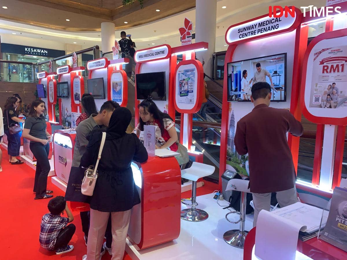 Pengunjung berbincang dengan perwakilan di stan pameran Malaysia Healthcare Expo 2026 di Sun Plaza Medan dengan dekorasi merah putih.