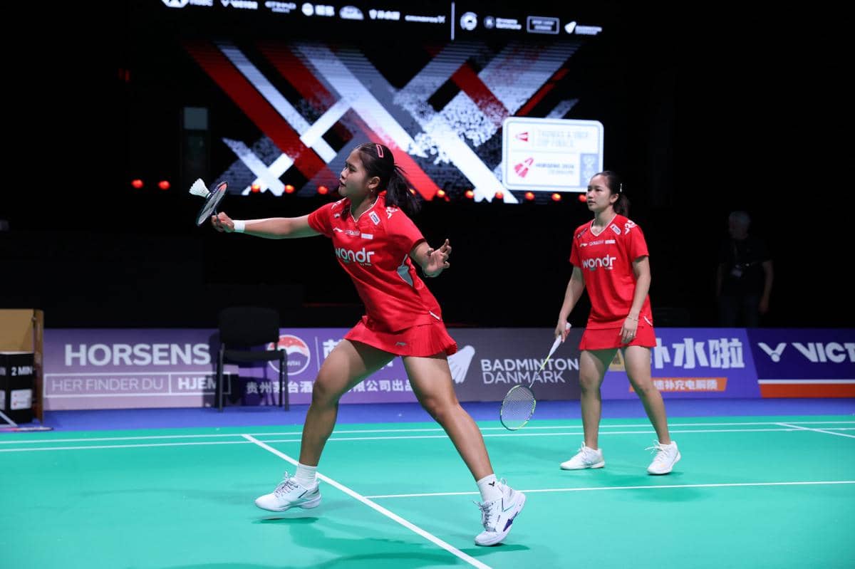 Dua atlet bulu tangkis putri Indonesia mengenakan seragam merah berlatih di lapangan menjelang kejuaraan Uber Cup 2026.