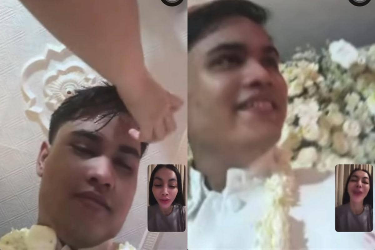 Tangkapan layar video call antara seorang pria mengenakan pakaian pengantin putih dengan seorang wanita yang tersenyum di layar kecil.