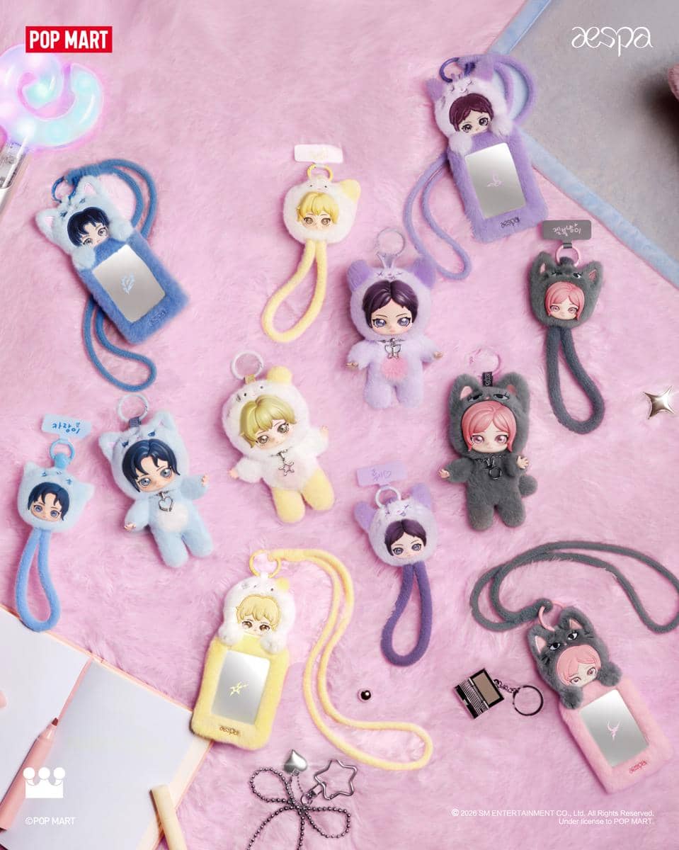 Boneka gantungan karakter aespa hasil kolaborasi dengan POP MART berwarna pastel, diletakkan di atas permukaan bulu lembut berwarna pink.