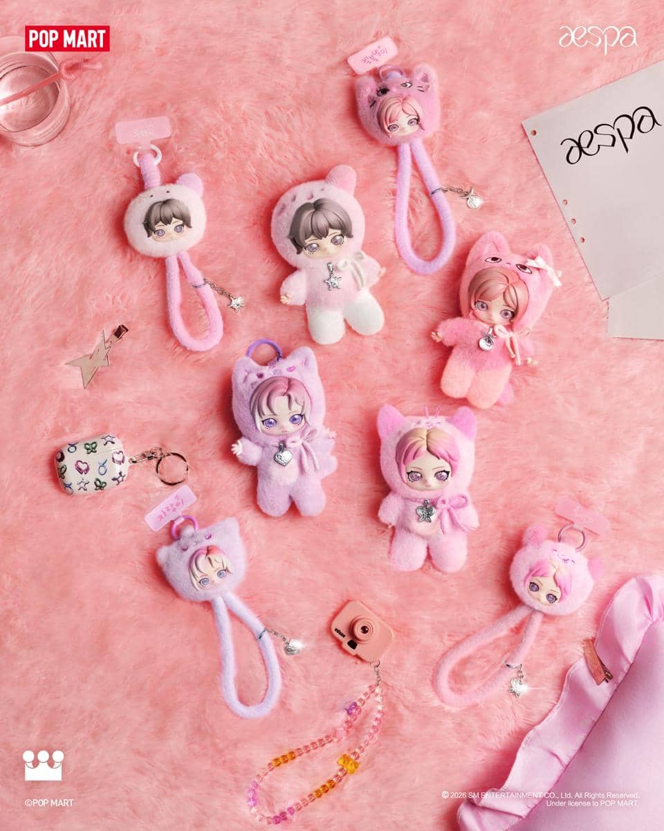 Boneka gantungan kolaborasi aespa dan POP MART dengan desain karakter lucu berwarna pink dan ungu di atas permukaan berbulu lembut.