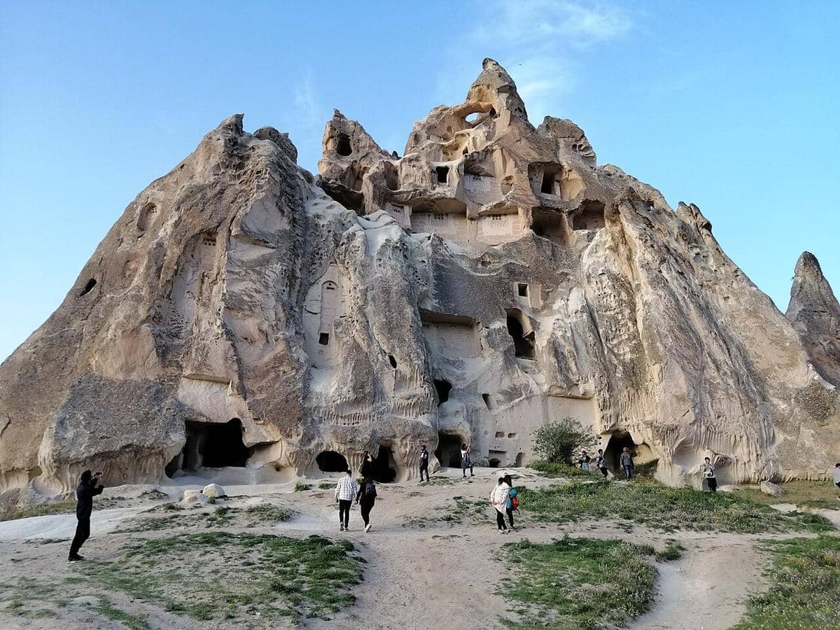 Para pengunjung yang menjelajahi formasi batuan bersejarah di Cappadocia, Turki, khususnya di area Museum Terbuka Göreme atau Kastil Uçhisar. 