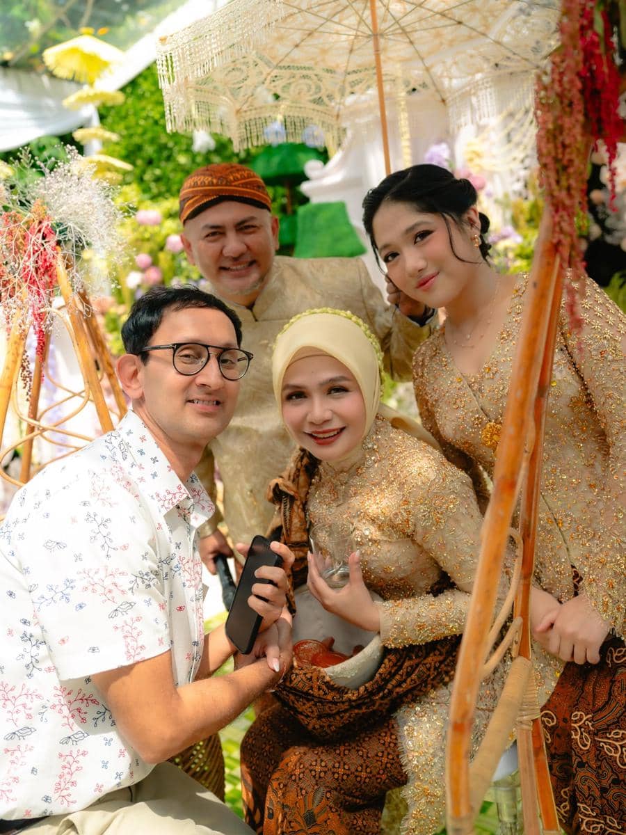 Empat orang berbusana tradisional Jawa berpose bersama di acara pengajian dan siraman dengan latar dekorasi bernuansa hijau dan emas.