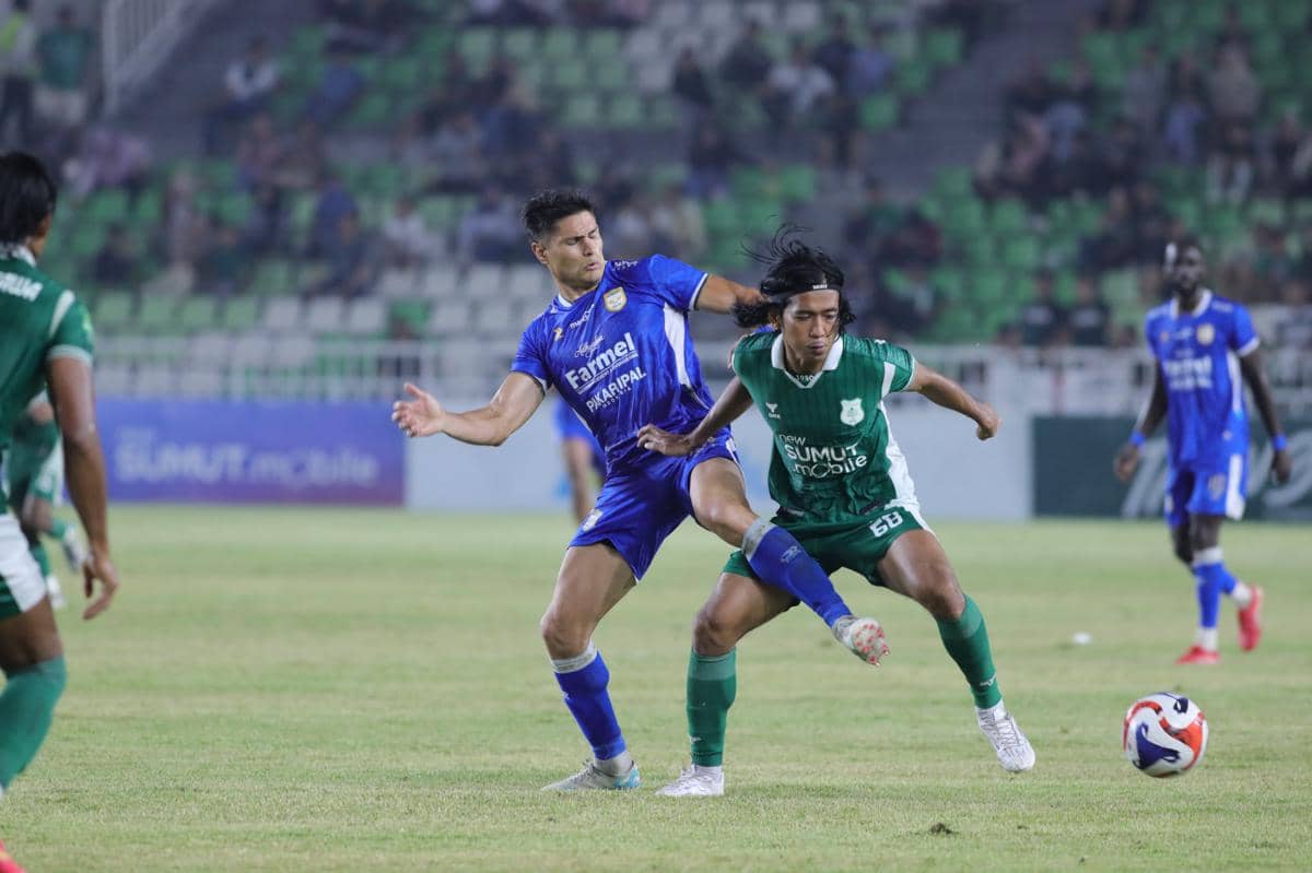 Pemain PSMS dan Adhyaksa FC berebut bola dalam pertandingan Championship di Stadion Utama Sumut dengan latar tribun penonton.