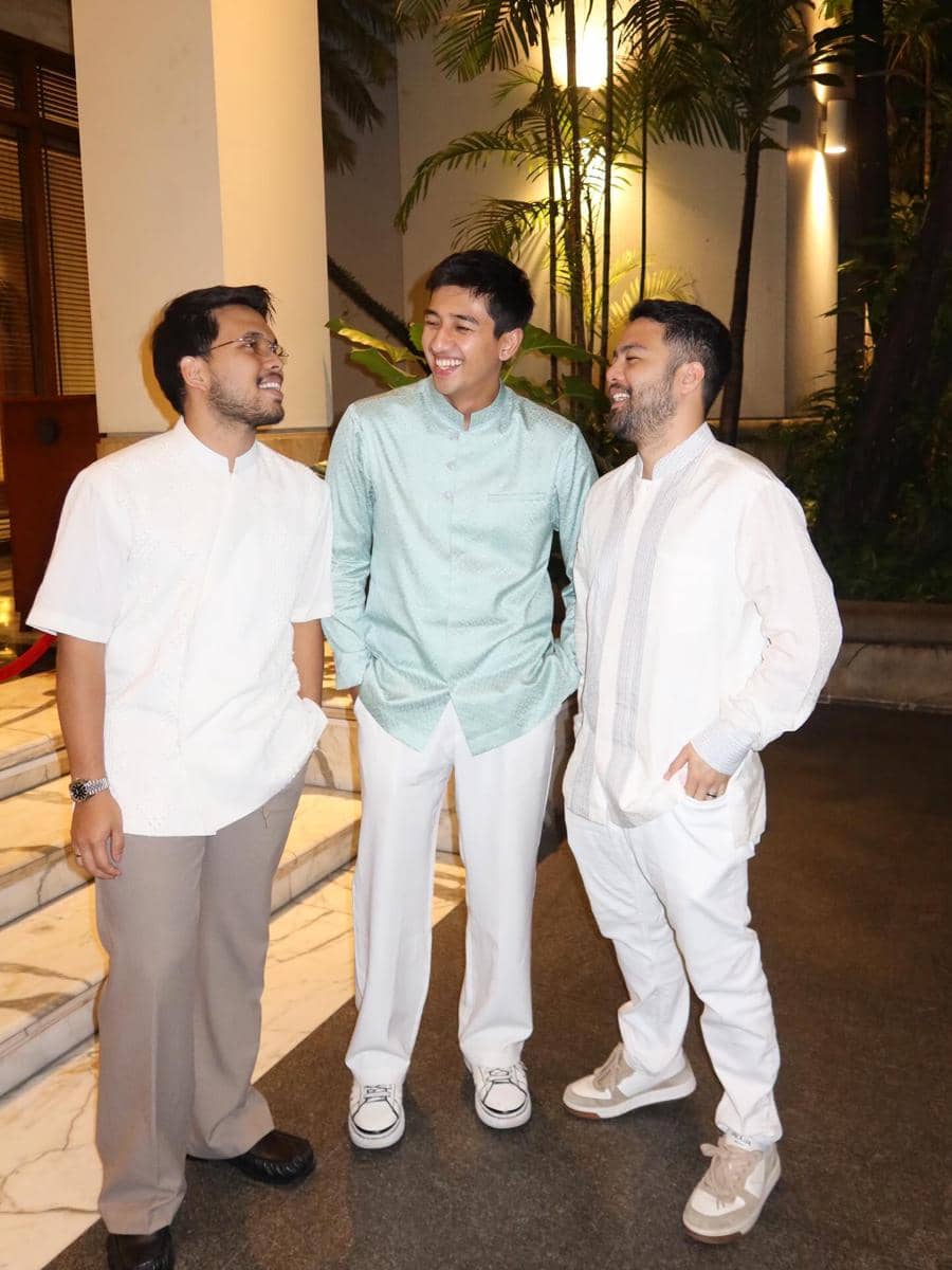 Thariq Halilintar, Harris Vriza mengenakan busana muslim berwarna cerah sedang tersenyum dan berbincang di area luar gedung pada malam hari.