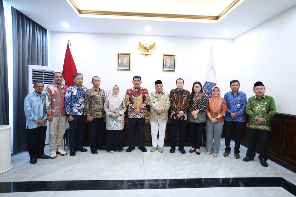 Sejumlah pejabat Pemprov Sulut dan perwakilan Kanwil Kementerian Haji dan Umroh Sulut berfoto bersama di ruang pertemuan resmi.