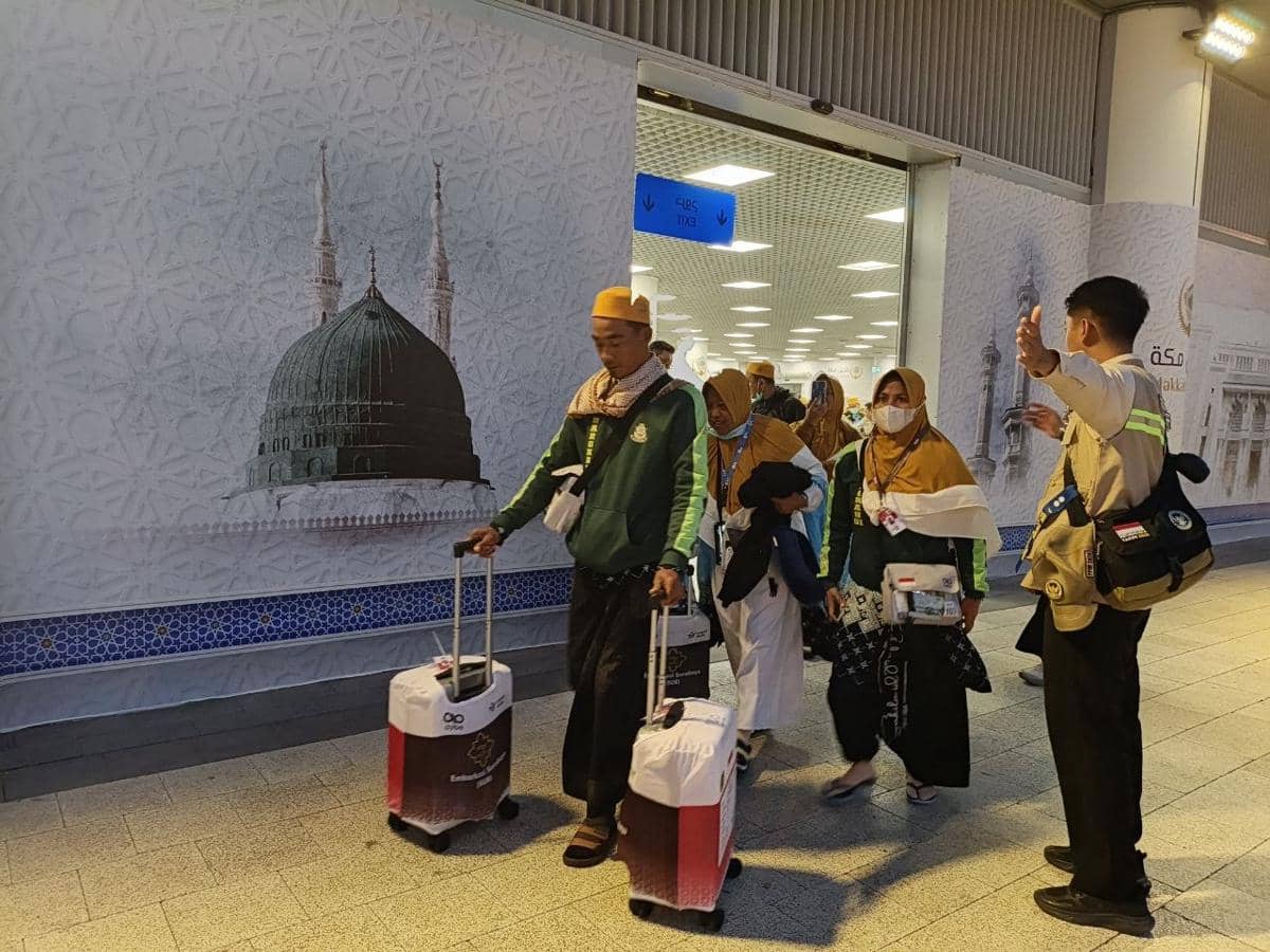 Rombongan jemaah haji embarkasi Surabaya dan Ujung Pandang tiba di bandara dengan membawa koper dan perlengkapan haji mereka.