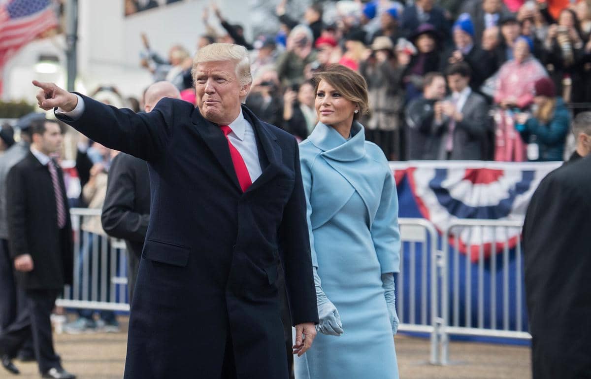 Donald Trump (kiri) dan istrinya, Melania Trump (kanan) sedang berjalan. 