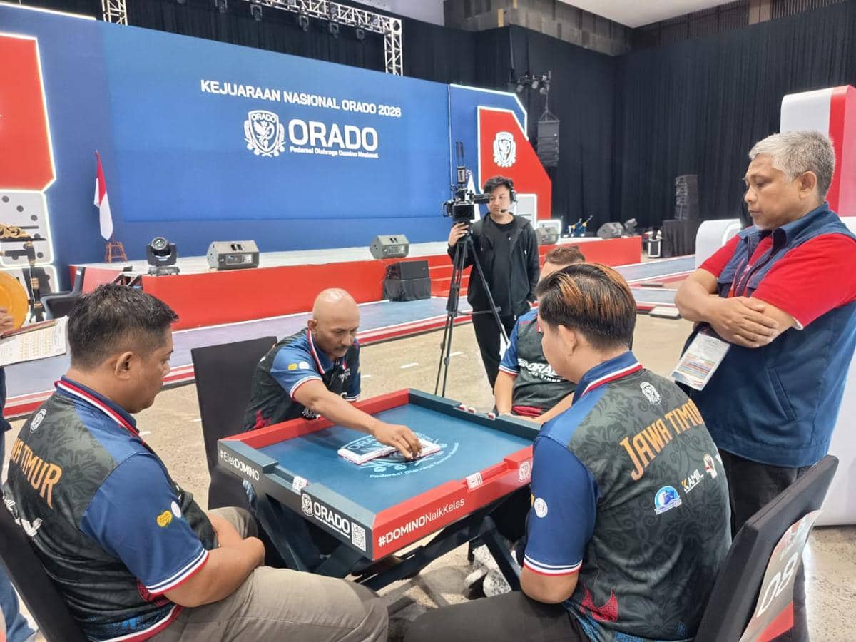 Beberapa peserta mengenakan seragam Jawa Timur bermain domino di meja turnamen dalam Kejurnas ORADO 2026 di Bogor.