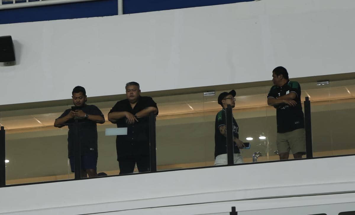 Beberapa pria berdiri di tribun VIP Stadion Utama Sumut saat pertandingan PSMS melawan Adhyaksa FC pada malam hari.