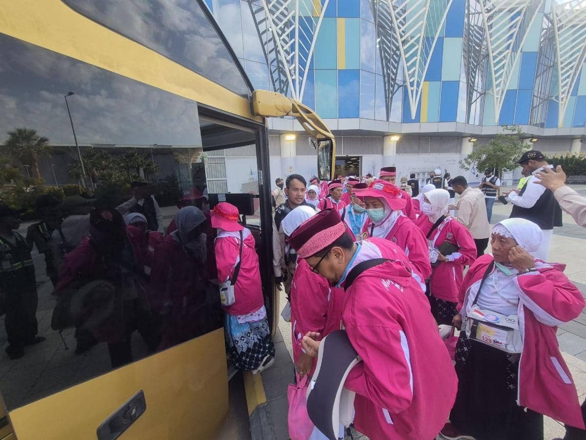 Rombongan jemaah haji asal Kota Malang mengenakan pakaian seragam merah muda bersiap menaiki bus setibanya di Madinah.