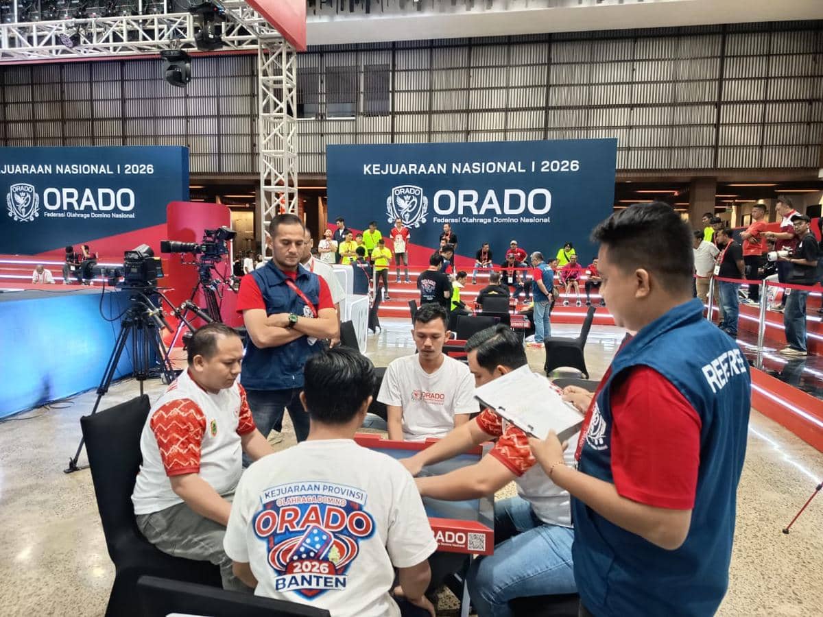 Beberapa peserta bermain domino dalam Kejurnas ORADO 2026 di Bogor dengan wasit memantau pertandingan di area indoor.