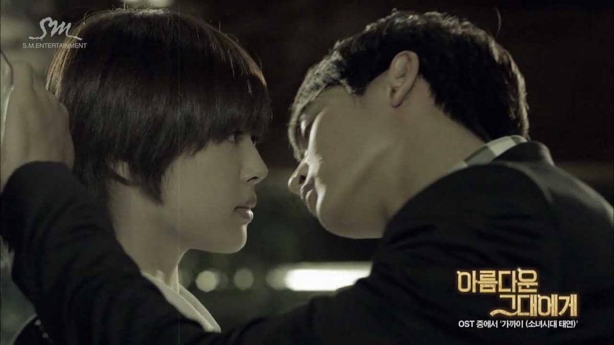 Dua karakter dalam adegan dramatis saling menatap dekat di cuplikan video musik lagu Closer untuk OST drama To the Beautiful You.