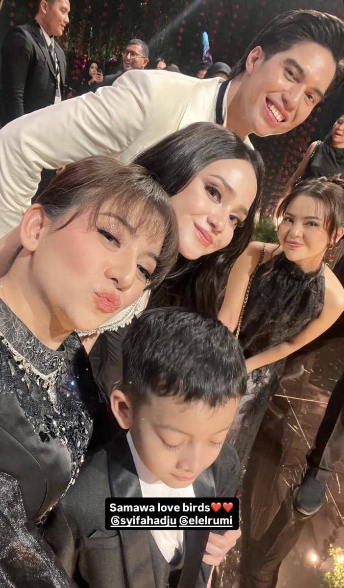 Rizkina Nazar berpose bersama teman-temannya di acara pernikahan dengan suasana meriah dan busana formal elegan.