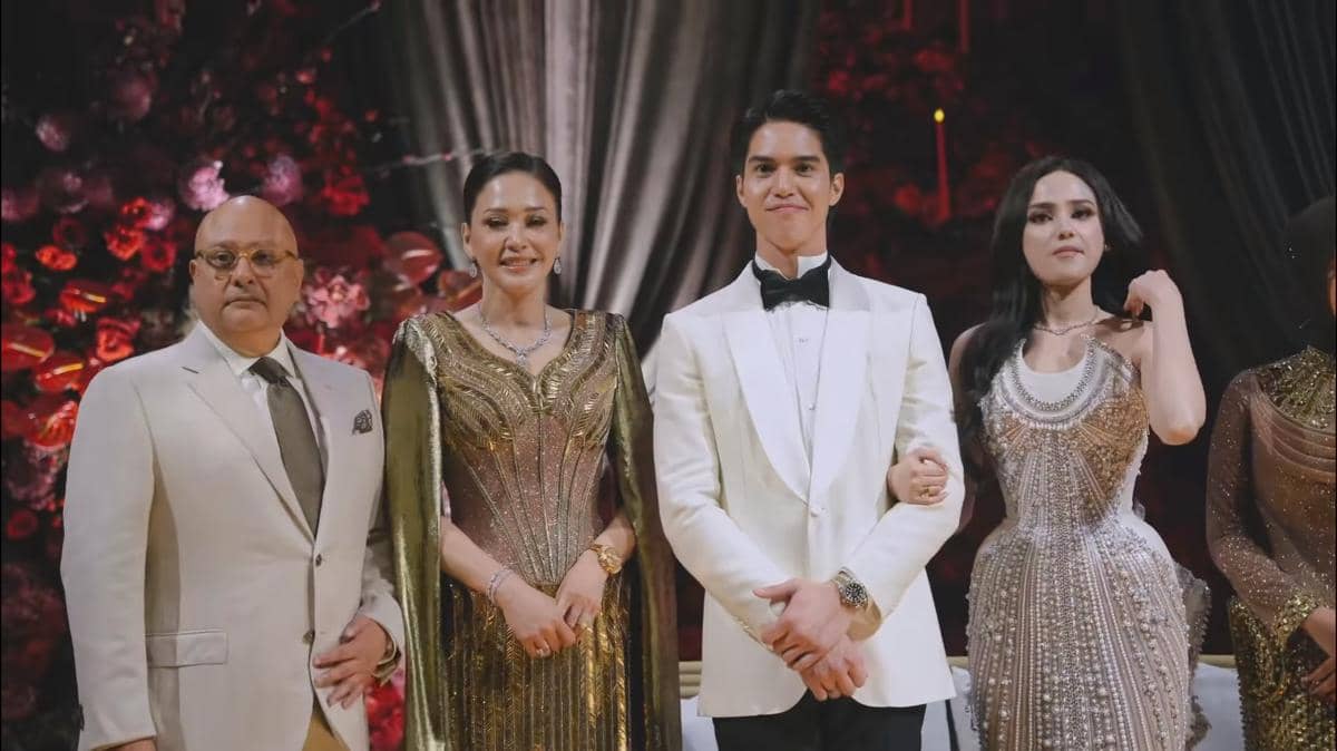 Empat orang berpose elegan mengenakan busana formal berwarna emas dan putih di acara resepsi dengan latar dekorasi bunga merah.