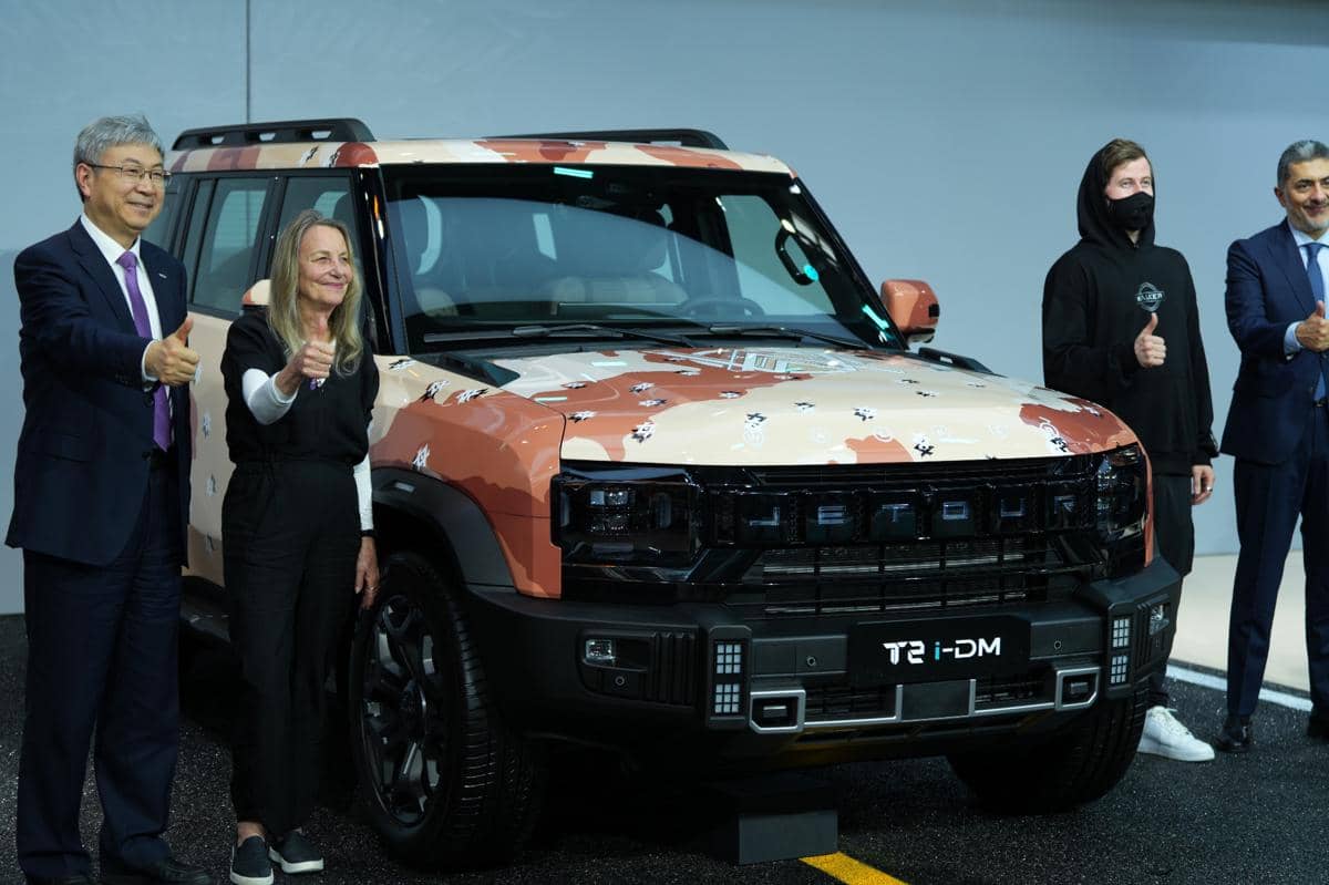 Beberapa orang berpose dengan mobil Jetour T2 i-DM bermotif kamuflase dalam acara kolaborasi Jetour dengan Alan Walker.