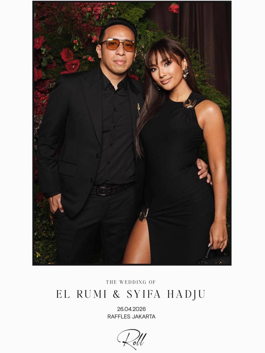 Sepasang tamu berpakaian hitam elegan berpose di resepsi pernikahan El Rumi dan Syifa Hadju di Raffles Jakarta.
