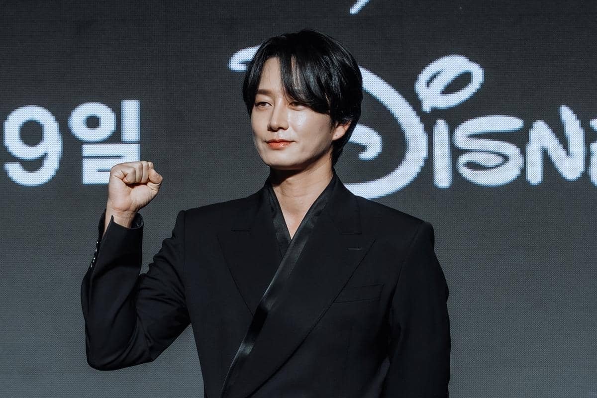 Seorang aktor mengenakan setelan hitam berpose dengan tangan mengepal saat konferensi pers drama Korea Gold Land di Seoul.