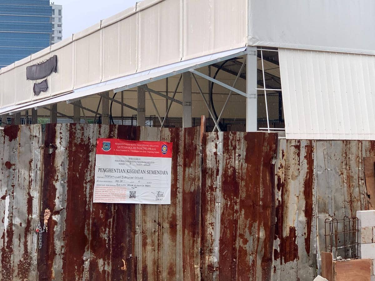 Lapangan padel di belakang Kelurahan Rawa Mekar, Tangerang Selatan disegel dengan pagar seng berkarat dan papan pemberitahuan penghentian kegiatan.