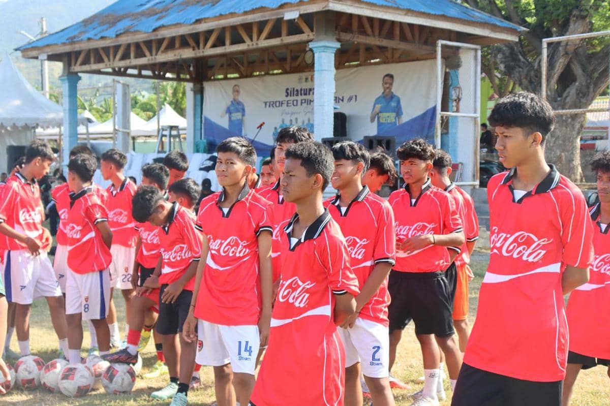 Sekelompok remaja mengenakan seragam sepak bola merah sedang berdiri di lapangan saat Festival Sepak Bola Rakyat di Palu.