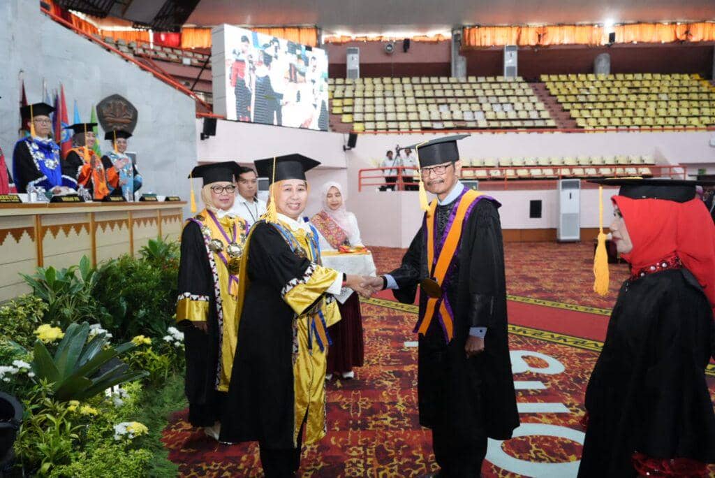 Suasana Rapat Senat Luar Biasa Unila di Gedung Serbaguna dengan dosen mengenakan toga akademik saat prosesi pengukuhan guru besar.