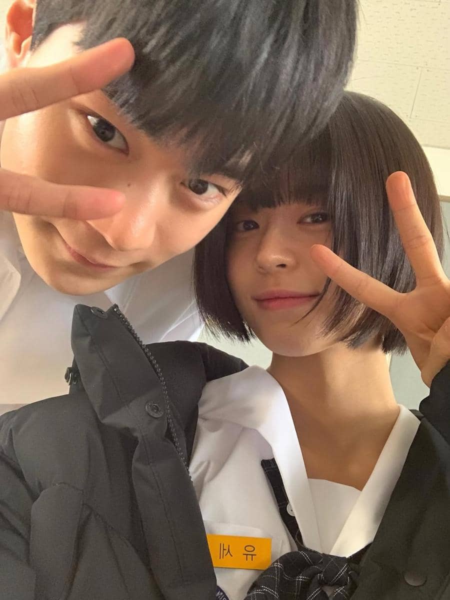 Dua pemeran drama Korea If Wishes Could Kill berpose bersama di belakang layar sambil menunjukkan tanda V dengan jari.