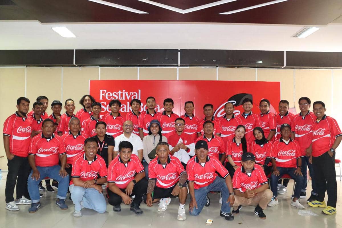 Sekelompok peserta mengenakan seragam merah berlogo Coca-Cola berfoto bersama di acara Festival Sepak Bola Rakyat di Palu.