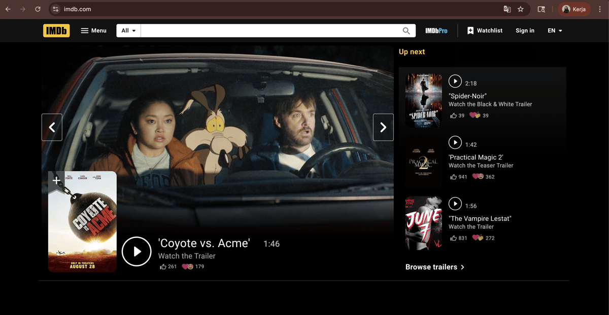 Tampilan laman utama IMDb menampilkan trailer film 'Coyote vs. Acme' dengan dua karakter duduk di dalam mobil dan daftar trailer lain di sisi kanan.