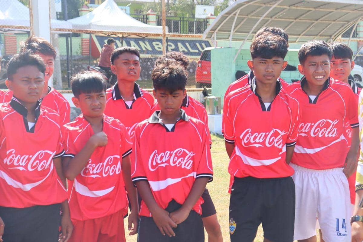 Sekelompok remaja mengenakan seragam sepak bola berwarna merah sedang berdiri di lapangan saat Festival Sepak Bola Rakyat di Palu.