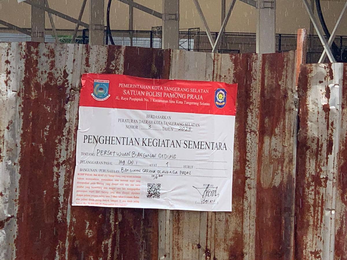 Papan penyegelan dari Satpol PP Kota Tangerang Selatan terpasang di pagar seng lapangan padel yang dihentikan kegiatannya karena tidak memiliki PBG.