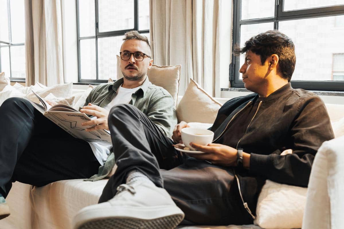 two men talking on sofa