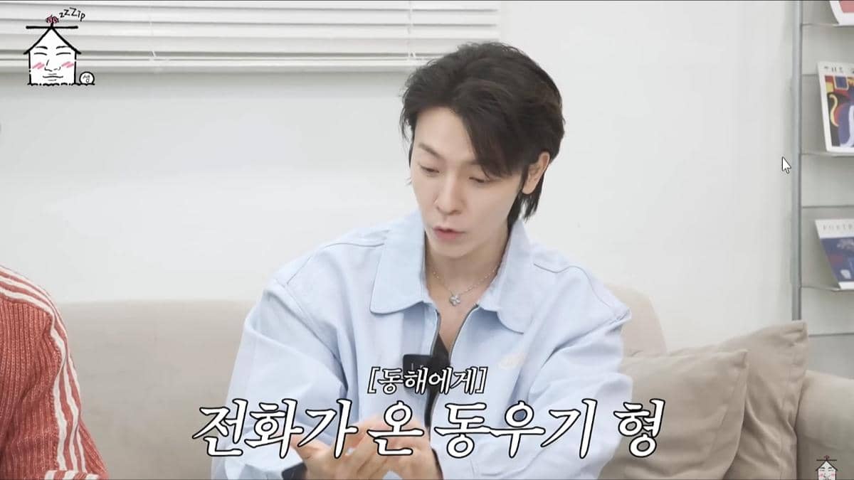 Seorang pria berambut hitam mengenakan kemeja biru muda sedang berbicara sambil duduk di sofa dalam konten YouTube ZIP DAESUNG.