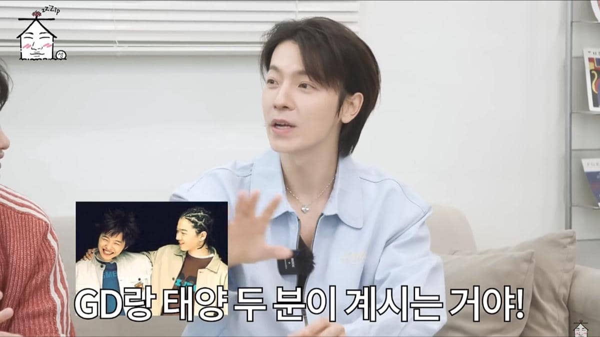 Seorang pria berambut cokelat mengenakan kemeja biru muda sedang berbicara di acara YouTube ZIP DAESUNG dengan layar sisipan menampilkan dua orang tersenyum.