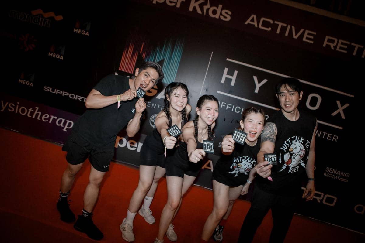 Lima peserta berpose gembira sambil memegang kartu Hyrox Race Simulation di acara Mega Fitness Center di kawasan Cemara Asri.