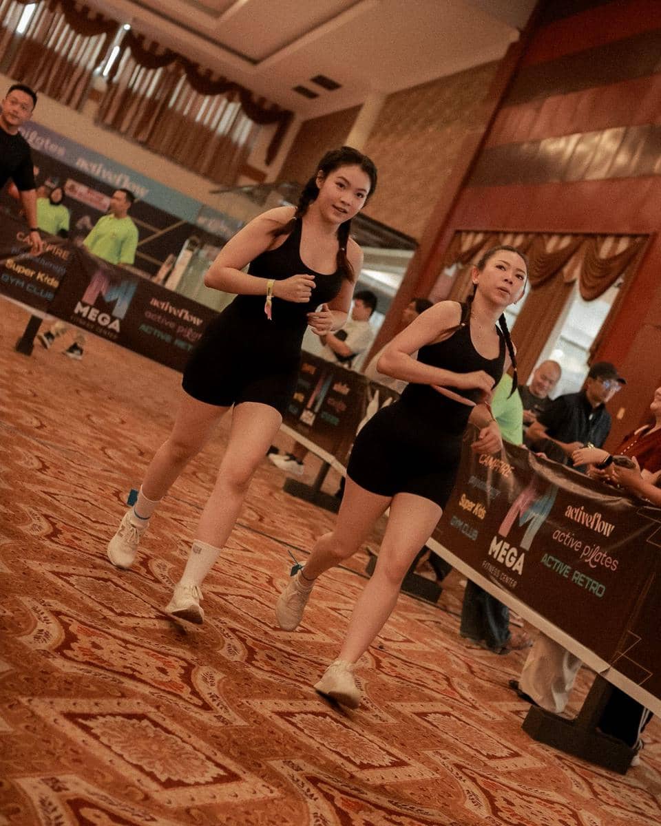 Dua peserta wanita berlari di dalam ruangan saat simulasi lomba Hyrox pertama di Medan yang diikuti ratusan peserta.