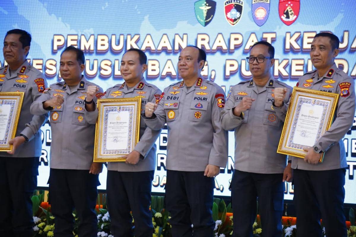 Sejumlah pejabat Polda Riau berpose sambil memegang piagam penghargaan dari Kepala Kepolisian Negara Republik Indonesia di sebuah acara resmi.