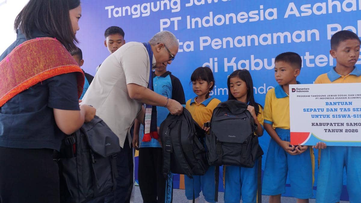 Perwakilan PT Inalum menyerahkan tas sekolah kepada siswa SD dalam program tanggung jawab sosial perusahaan di Kabupaten Samosir.