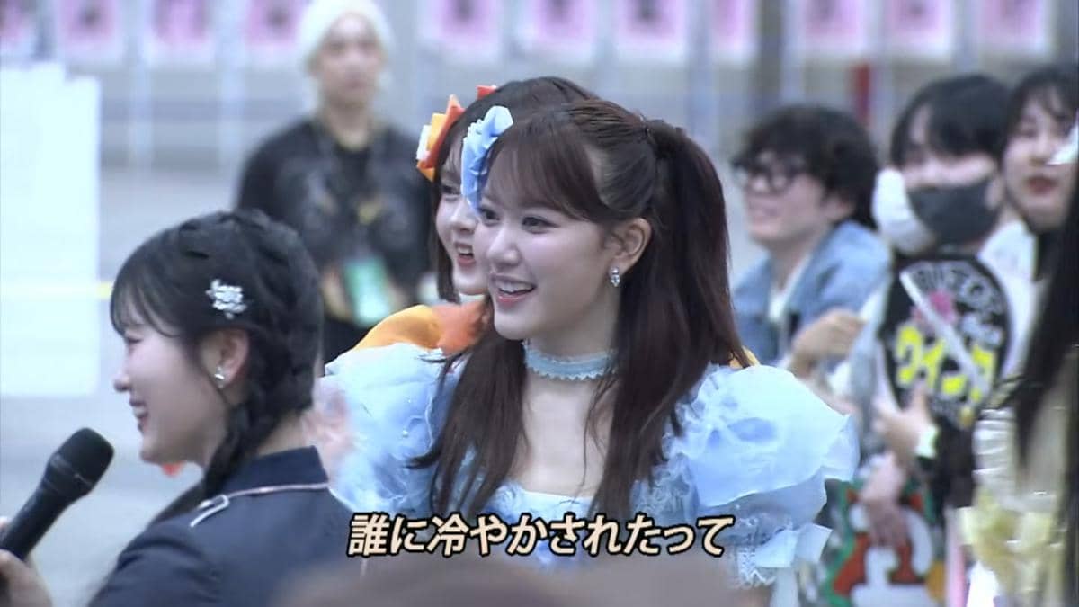 Anggota JKT48 mengenakan kostum panggung berwarna biru muda tersenyum saat menghadiri acara handshake AKB48 tahun 2026.