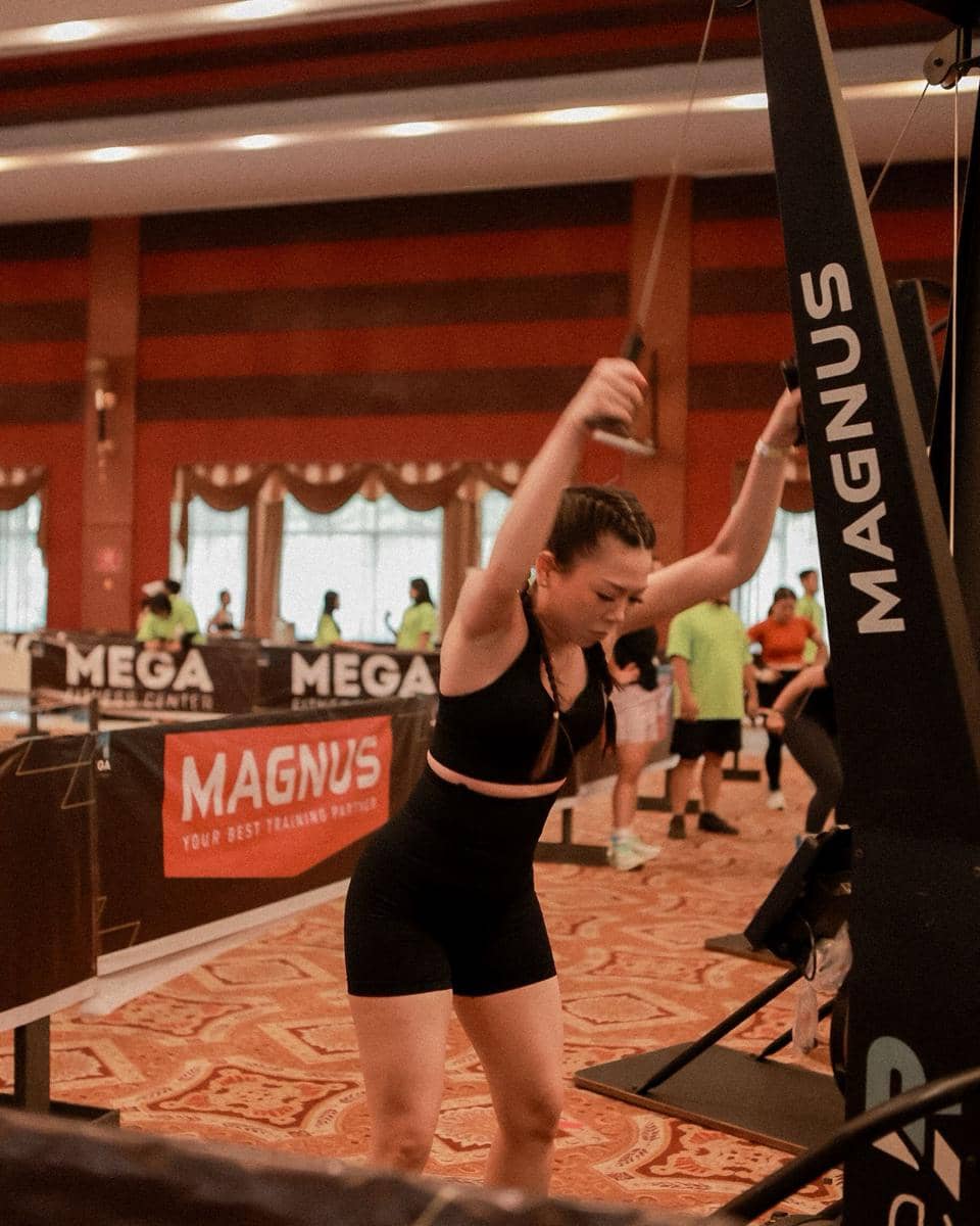 Seorang peserta wanita berolahraga menggunakan mesin latihan di acara Hyrox Race Simulation yang digelar Mega Fitness Center di Cemara Asri.