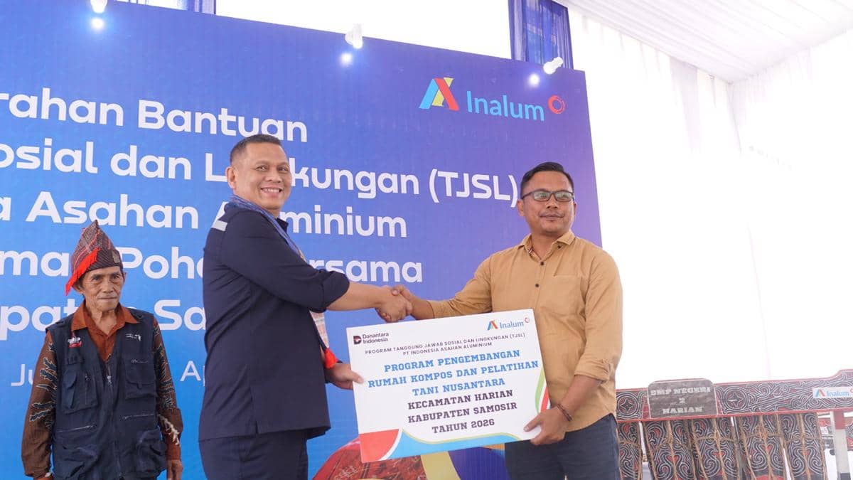 Perwakilan PT Inalum menyerahkan bantuan program TJSL kepada penerima di Kabupaten Samosir dengan latar spanduk acara resmi.