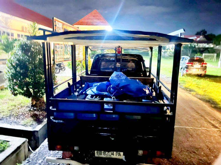 Mobil bak terbuka berisi jeriken tertutup terpal biru sebagai barang bukti penyelundupan Pertalite di Manggarai Timur pada malam hari.