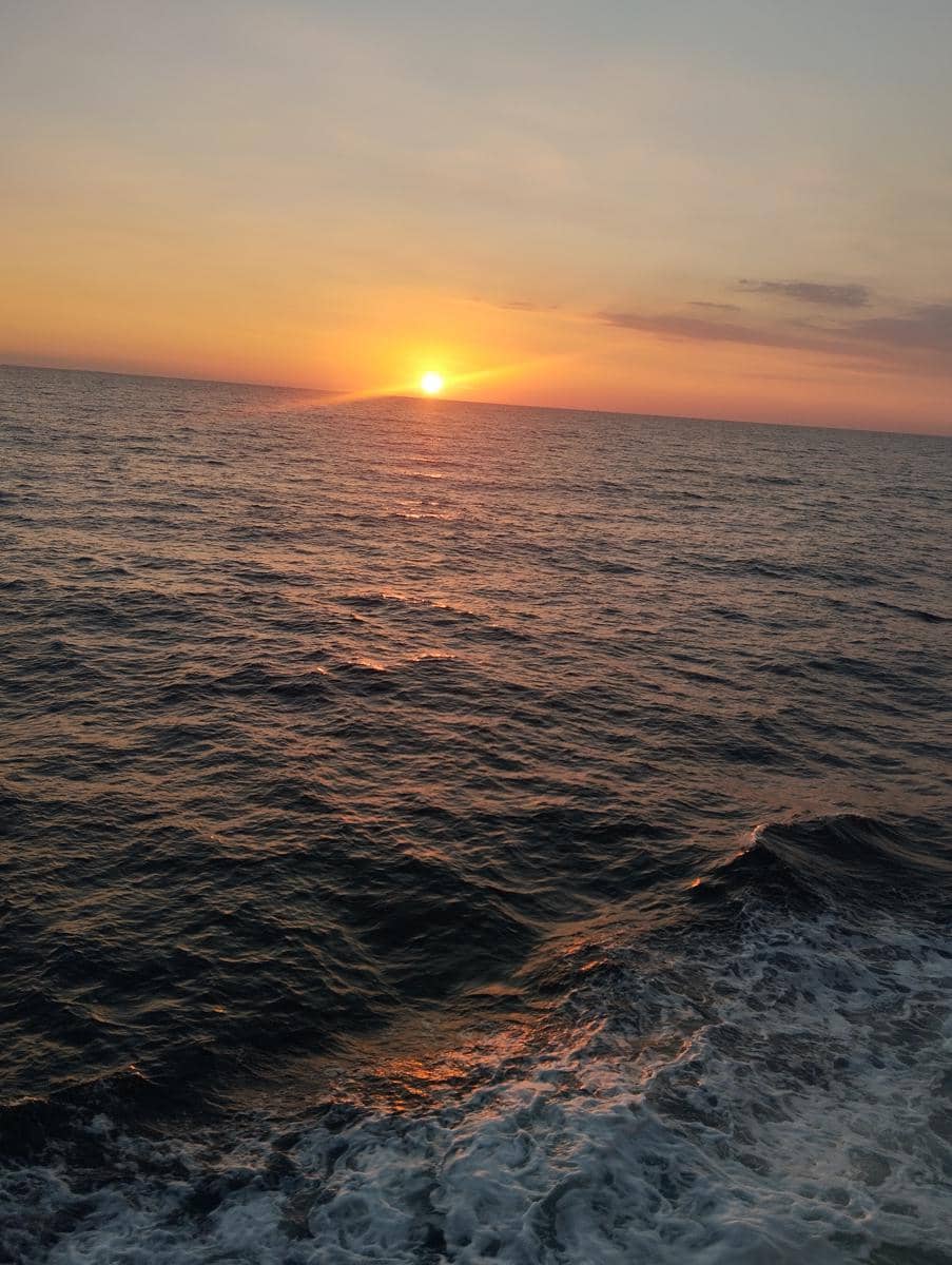 Pemandangan laut dan langit fajar, menggambarkan ketenangan setelah lepas dari judi online