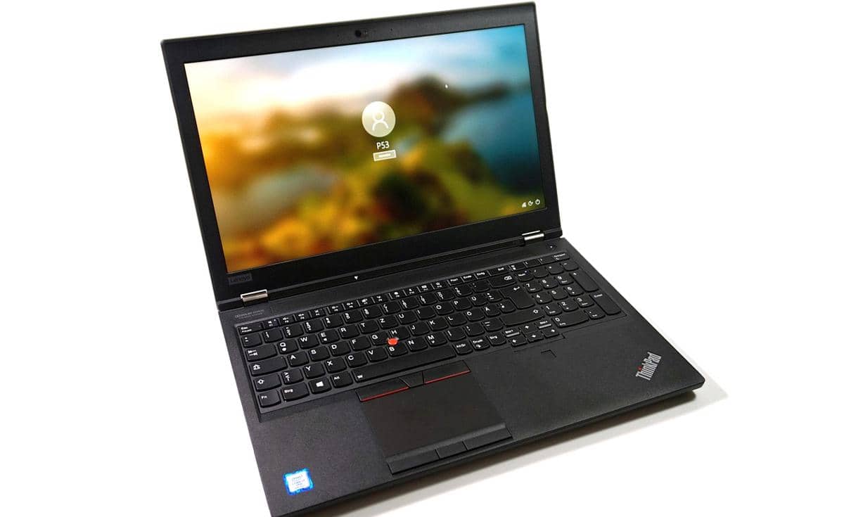 Laptop Lenovo ThinkPad seri T atau X berwarna hitam dengan layar menyala menampilkan tampilan login pengguna di atas meja putih.
