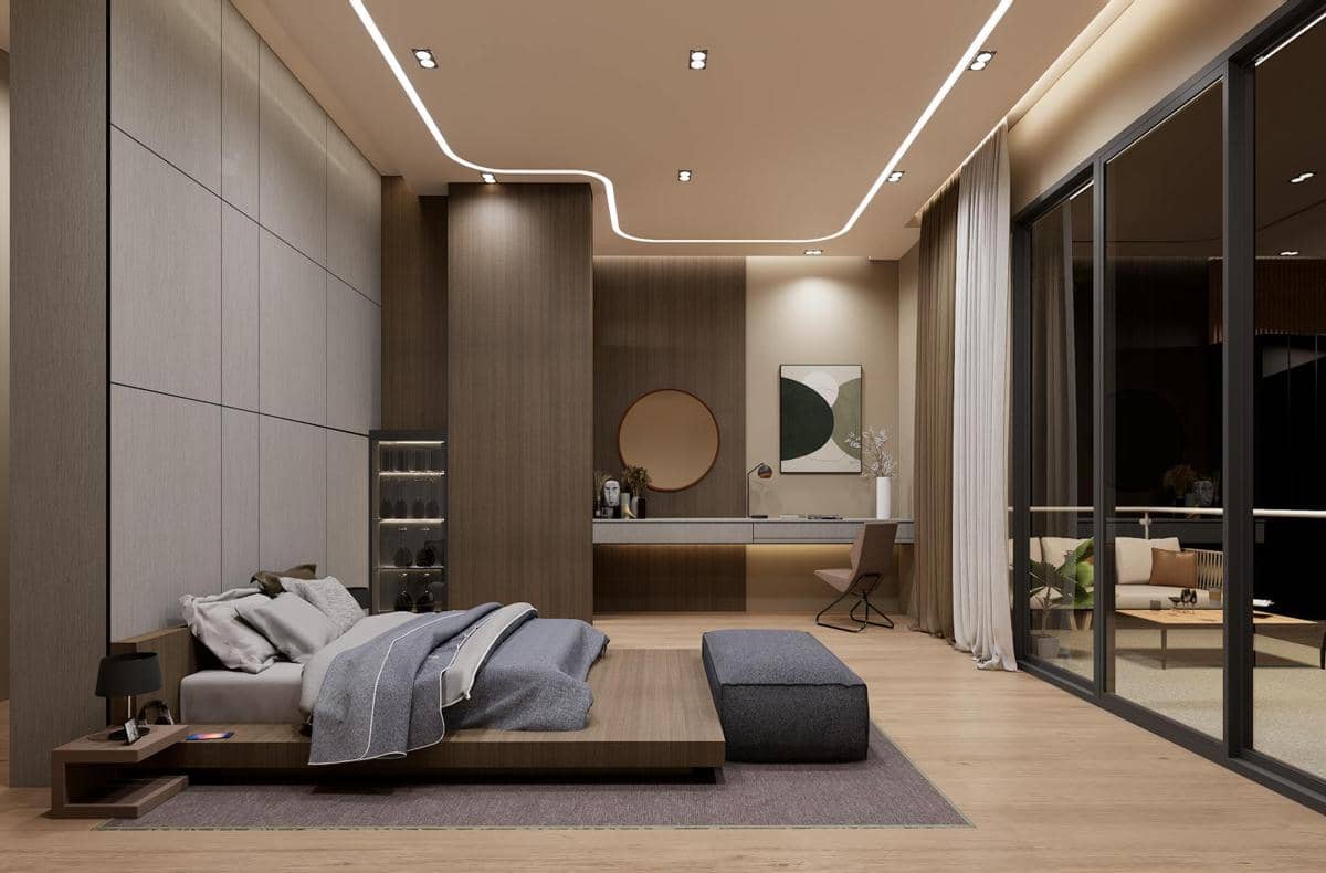 Kamar tidur modern dengan pencahayaan lembut, tempat tidur rendah berwarna abu-abu, meja kerja minimalis, dan jendela besar ke balkon.