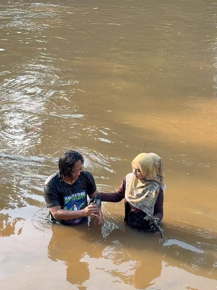 Ria Ricis menangkap ikan sapu-sapu di Sungai Ciliwung