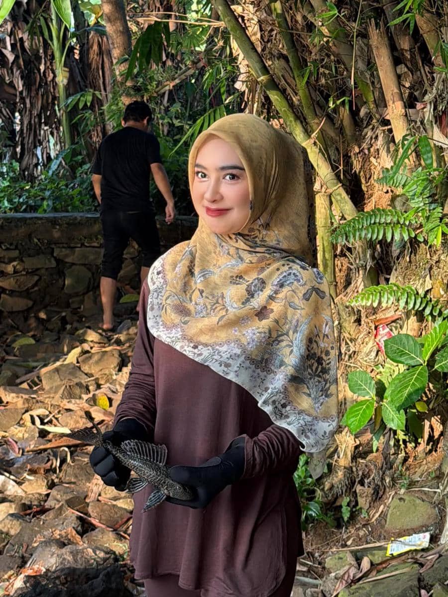 Ria Ricis menangkap ikan sapu-sapu di Sungai Ciliwung